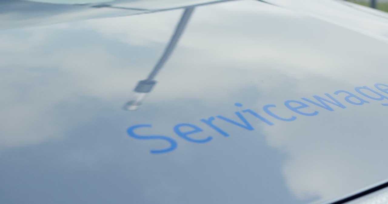 Detailansicht der Motorhaube eines silbernen Servicewagens mit Warnmarkierung