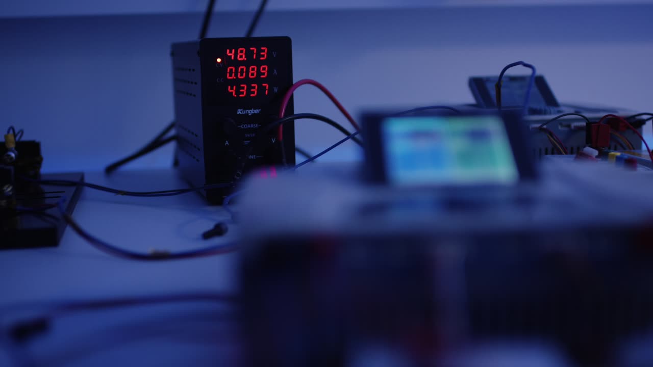 Digitales Labornetzteil mit roter LED Anzeige und Kabelverbindungen auf einem Pruefstand