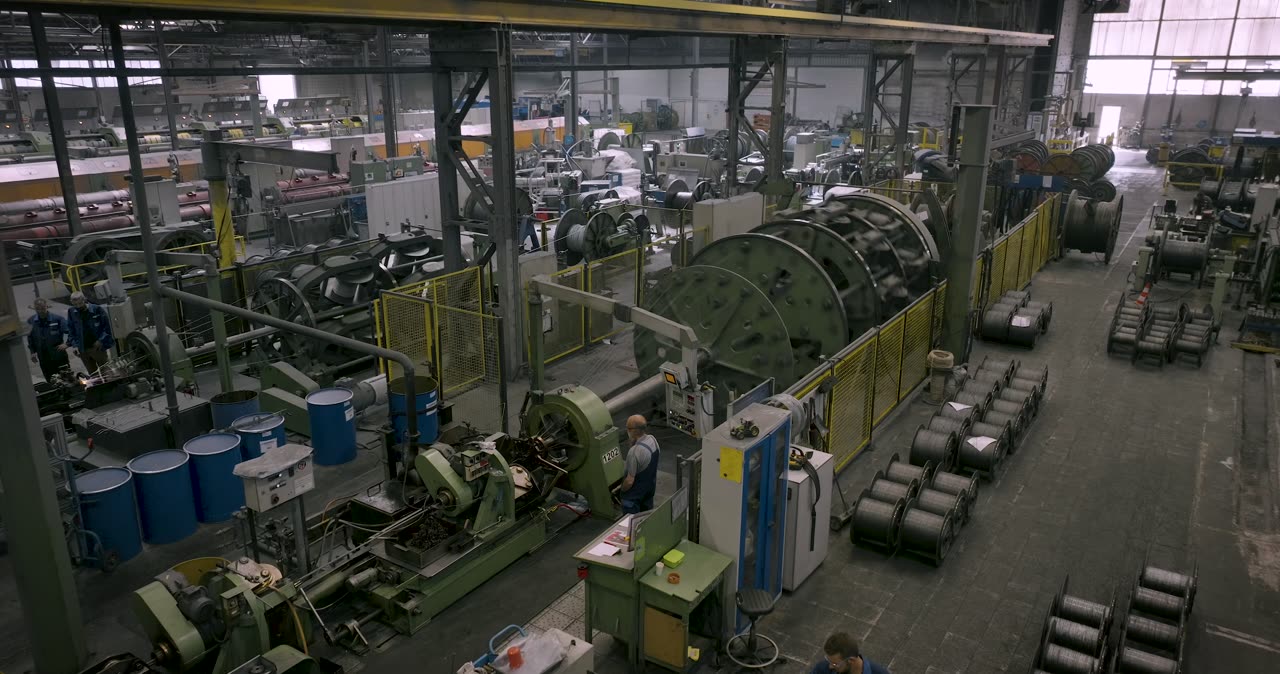 Große rotierende Korbverseilmaschine zur Fertigung von Stahlseilen in einer Industriehalle
