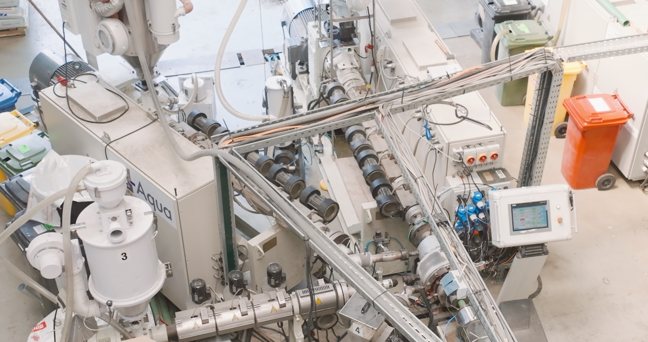 Industrielle Extrusionsanlage in einer Fabrikhalle zur Kunststoffverarbeitung in der Draufsicht