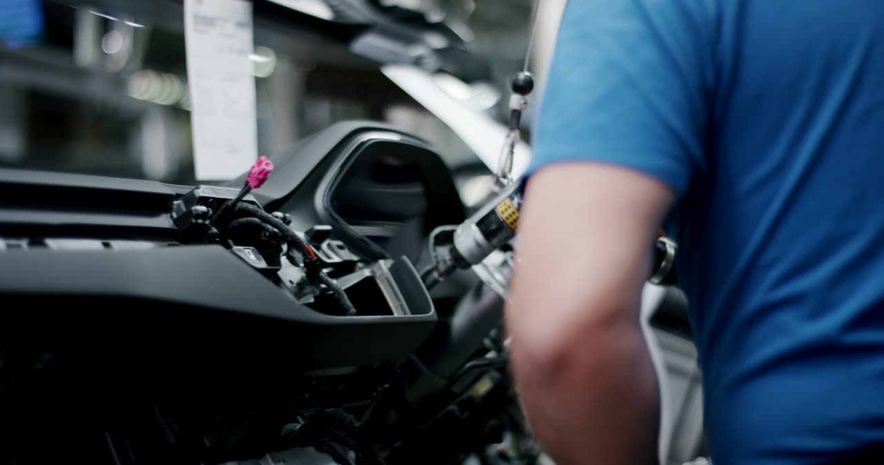 Montage eines Armaturenbretts mit einem Akkuschrauber in der Automobilproduktion