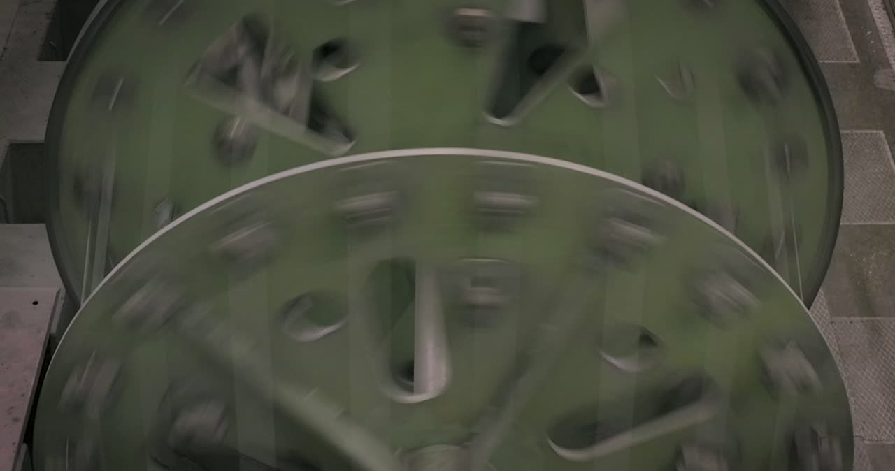 Nahaufnahme der rotierenden Elemente einer Korbverseilmaschine bei der Produktion von Stahlseilen