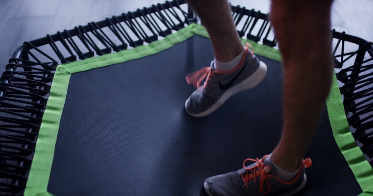 Person beim Training mit Sportschuhen auf einem kleinen Fitnesstrampolin