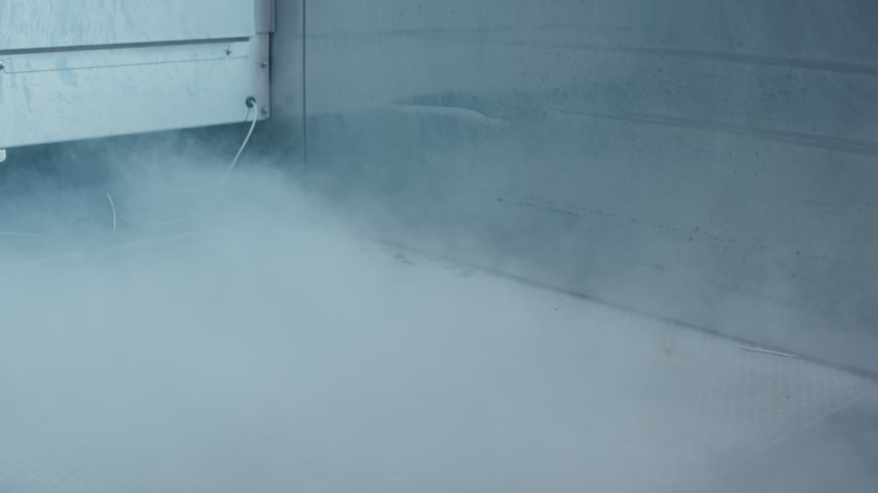 Title:
Dichter Nebel strömt durch den Innenraum einer industriellen Prüfkammer