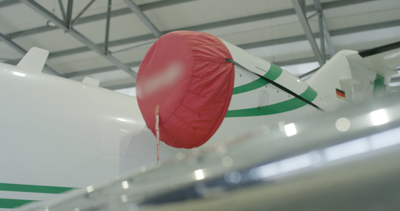 Triebwerk eines Privatjets mit roter Schutzabdeckung und „Remove Before Flight“-Anhänger im Hangar