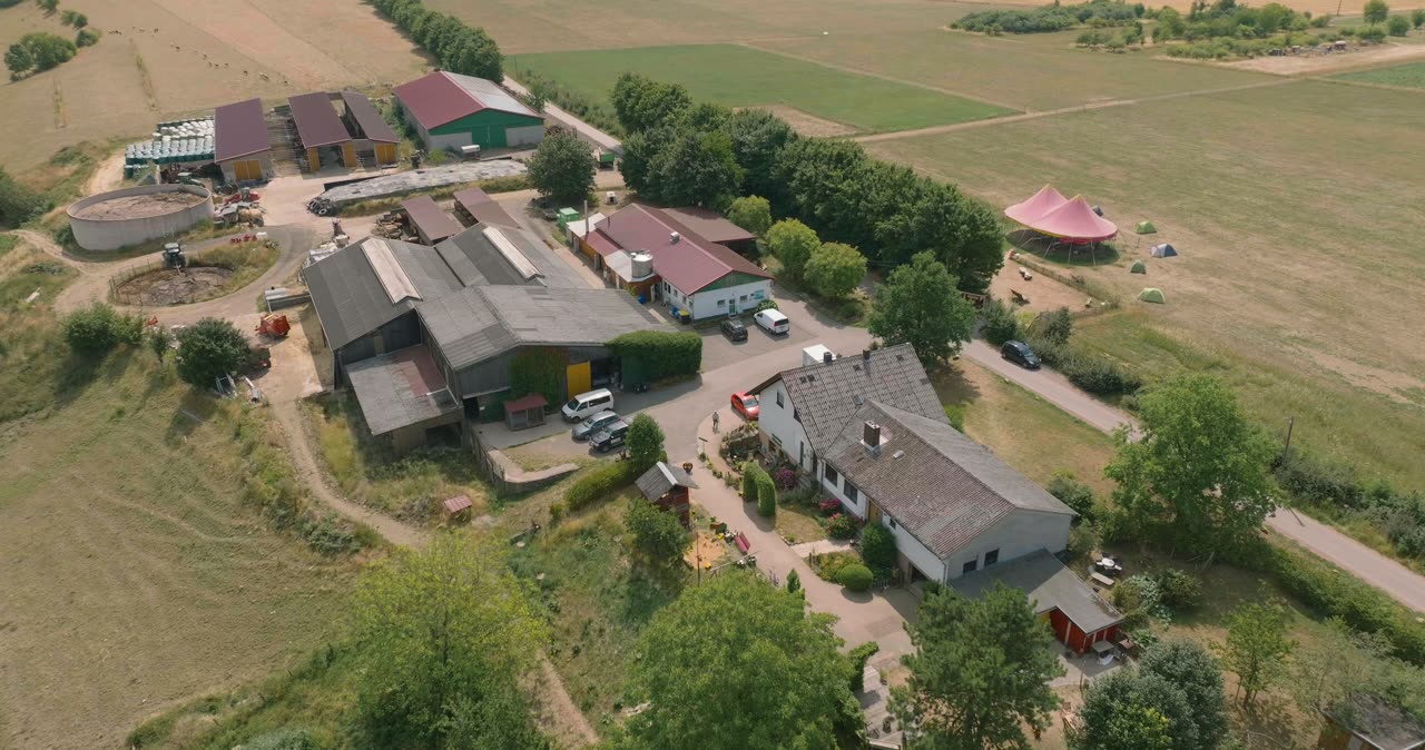 Vogelperspektive auf eine weitläufige landwirtschaftliche Hofanlage mit Wohnhaus